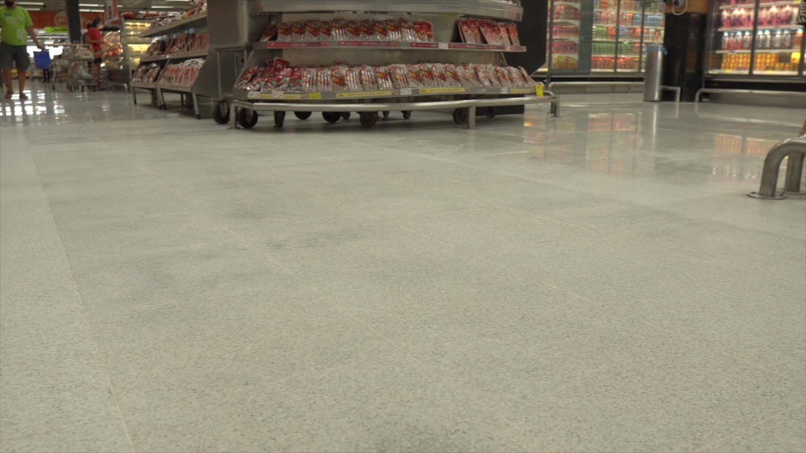 Corredor de supermercado com o piso fosco, filmado rente ao chão