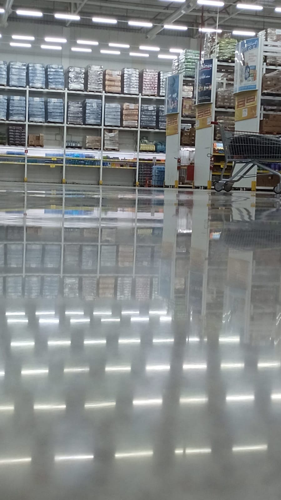 Plano geral de atacarejo com a grade de luminárias refletida no piso